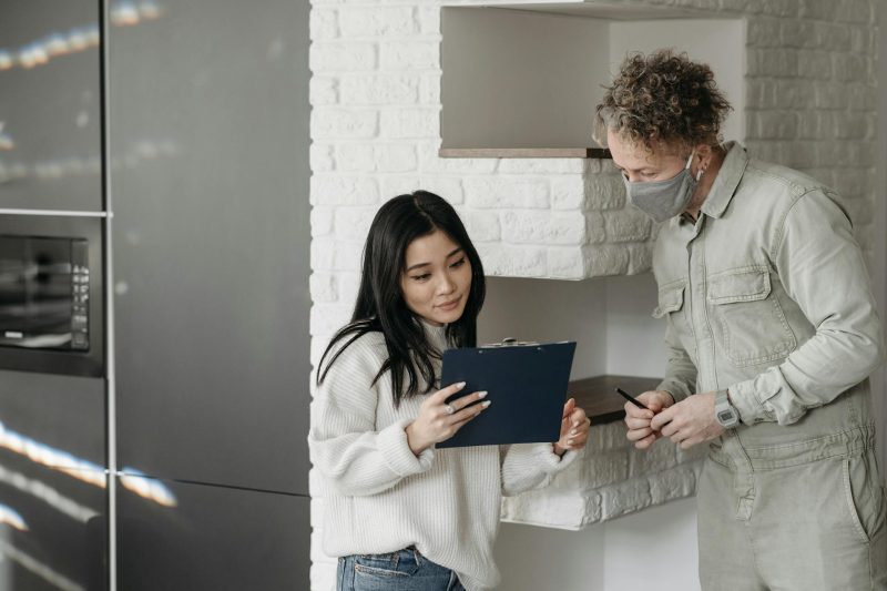 Masked courier and woman interacting indoors