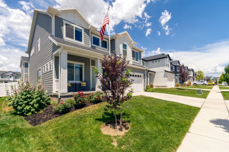Modern suburban house with a garden and an American flag, highlighting beautiful architectural features.