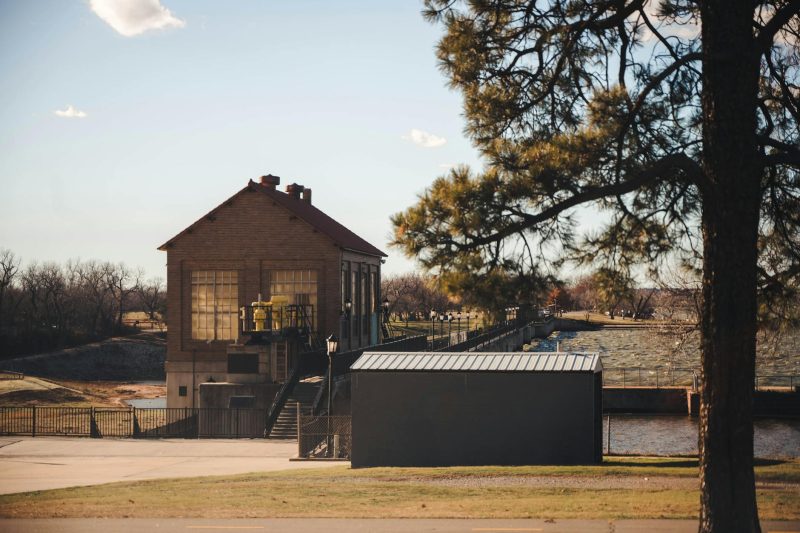 Historic building near Lake Overholser Dam, surrounded by clear skies and lush greenery.