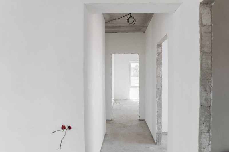 Unfinished building interior featuring white walls and door frames, showcasing a minimalist design.