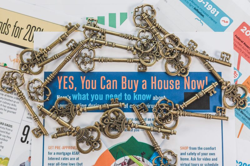 Vintage keys arranged atop real estate documents, symbolizing property ownership and investment.